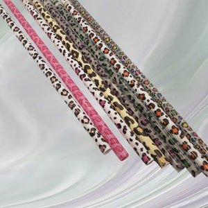 May include: A set of eight colorful straws with a leopard print design. The straws are made of plastic and are perfect for adding a touch of fun to your next party.