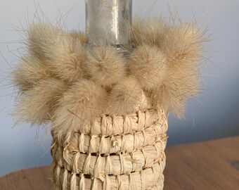 Handmade aboriginal weaving covered vintage bottle with bunny tails