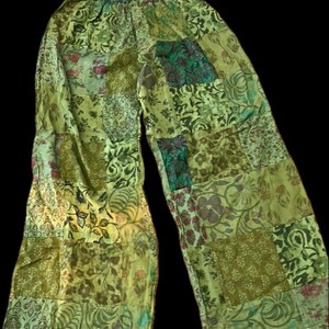 May include: Green patchwork pants with a floral pattern. The pants have an elastic waistband and a wide leg.