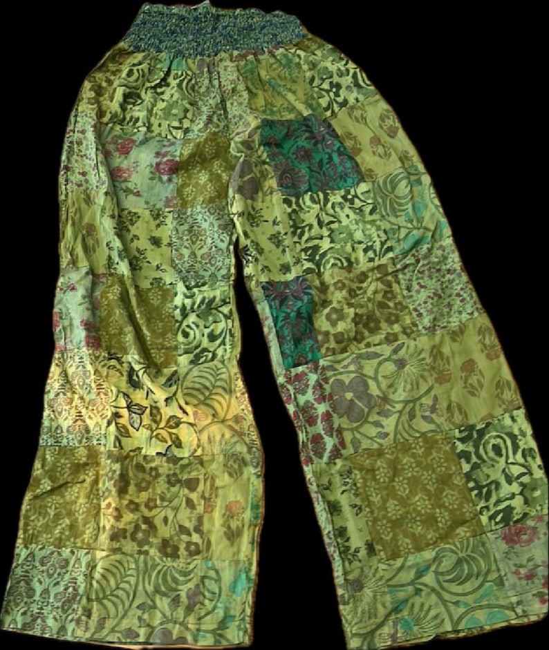 May include: Green patchwork pants with a floral pattern. The pants have an elastic waistband and a wide leg.