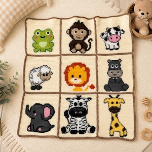 May include: A cream-colored, crocheted baby blanket featuring nine squares, each with a different animal: a frog, monkey, cow, sheep, lion, hippo, elephant, zebra, and giraffe. The blanket has a brown border and is surrounded by a soft, cream-colored surface.