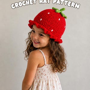 May include: A red crochet hat shaped like a strawberry with a green stem on top and small white embroidered dots. The hat features a ruffled brim. The text reads: STRAWBERRY CROCHET HAT PATTERN and SIZES NEWBORN TO 10 YEAROLD.