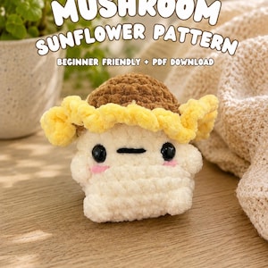 May include: A crochet plush toy shaped like a mushroom with a brown cap and a yellow ruffled sunflower petal border. The white base features two black plastic eyes, a small black horizontal mouth, and two pink stitched cheeks. Text reads MUSHROOM SUNFLOWER PATTERN BEGINNER FRIENDLY + PDF DOWNLOAD.