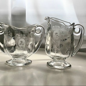 Peut inclure: Un ensemble vintage de pot à crème et sucrier en verre avec un motif floral gravé. L'ensemble est en verre transparent avec un motif floral délicat.