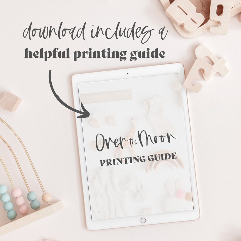 May include: A digital tablet shows a printing guide titled "Over the Moon." Wooden toys, including a bead maze and alphabet blocks, surround the tablet. The text "download includes a helpful printing guide" is at the top of the image.