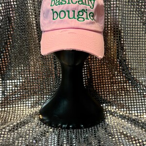 Puede incluir: Gorra de b&eacute;isbol rosa con el texto "basically bougie" bordado en verde.