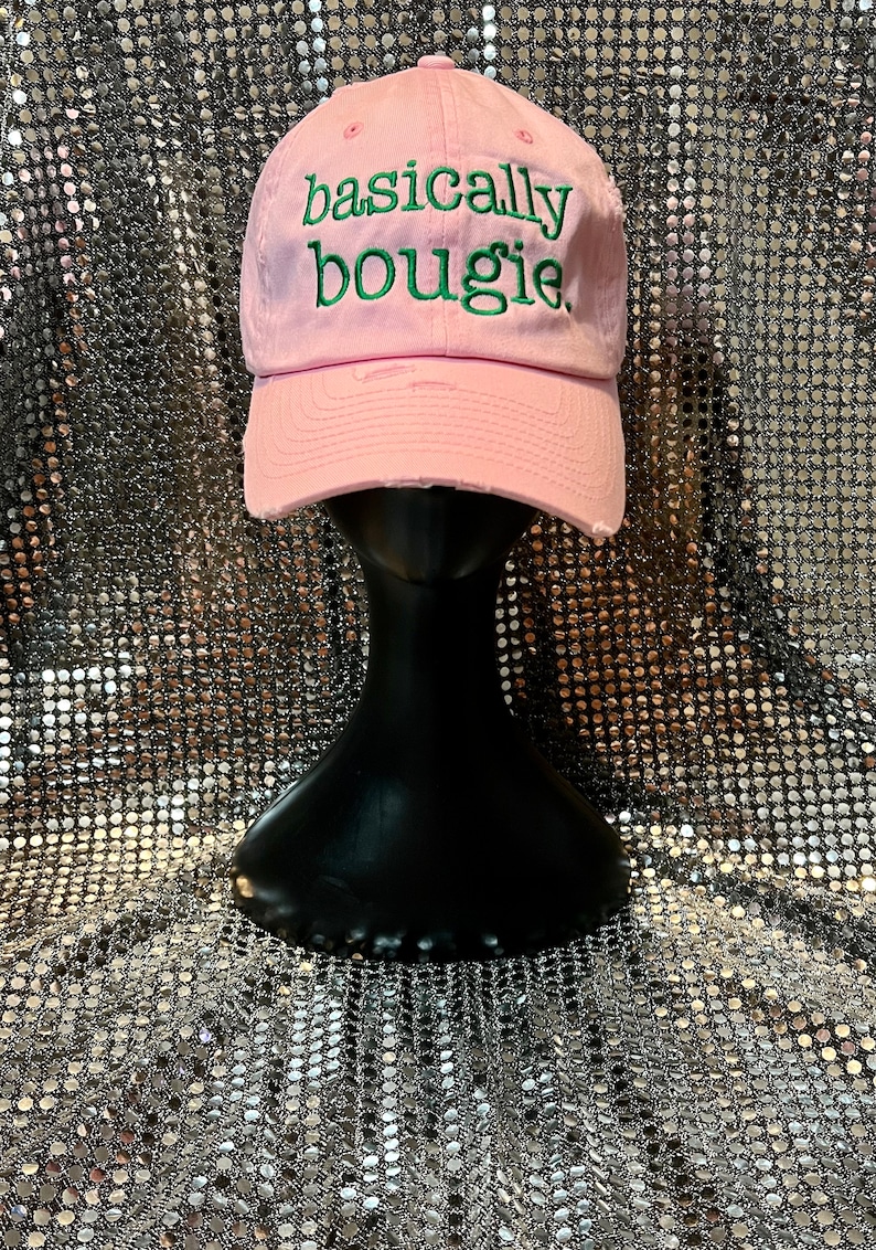 Puede incluir: Gorra de b&eacute;isbol rosa con el texto "basically bougie" bordado en verde.
