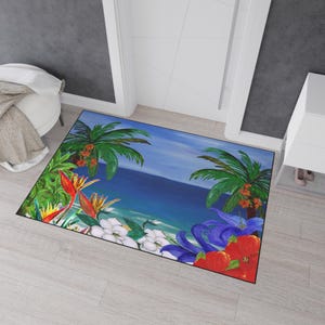 May include: A rectangular doormat featuring a tropical beach scene. The design includes palm trees, vibrant flowers, and a blue ocean under a clear sky. The mat is framed with a black border.
