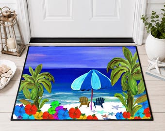 May include: A rectangular doormat featuring a painted beach scene with two palm trees, a blue and light blue beach umbrella, two chairs on white sand, and colorful red, yellow, and blue hibiscus flowers along the bottom edge of the mat.