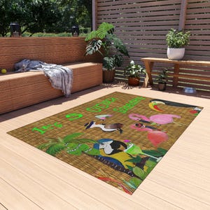 Puede incluir: Una alfombra rectangular con fondo de textura tejida color canela que presenta el texto verde brillante It's 5 O'clock Somewhere. El diseño incluye ilustraciones coloridas de un tucán, un flamenco rosa, un loro, una palmera y una copa de cóctel.
