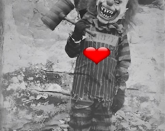 Può includere: Una foto in bianco e nero di un clown che indossa una tuta a righe e una maschera spaventosa. Il clown tiene un grosso martello e ha un cuore rosso disegnato sul petto.