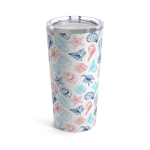 Puede incluir: Un vaso de acero inoxidable blanco con un patrón de conchas marinas azules y rosas. El vaso tiene una tapa y es perfecto para mantener las bebidas frías o calientes.
