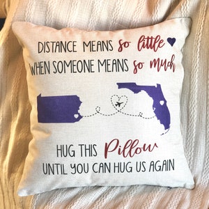 May include: A white pillow with the text "DISTANCE MEANS so little WHEN SOMEONE MEANS so much" and "HUG THIS Pillow UNTIL YOU CAN HUG US AGAIN". The pillow also features a purple outline of Pennsylvania and Florida with a red airplane flying between them.