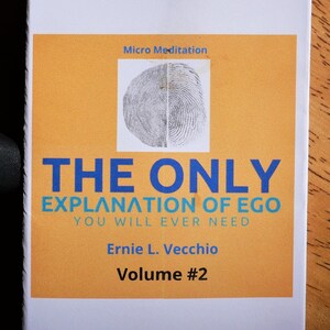 Op de afbeelding: Een boek getiteld "The Only Explanation of Ego You Will Ever Need" door Ernie L. Vecchio, Volume #2. De omslag van het boek toont een vingerafdrukbeeld en de tekst "Micro Meditation" in blauw.