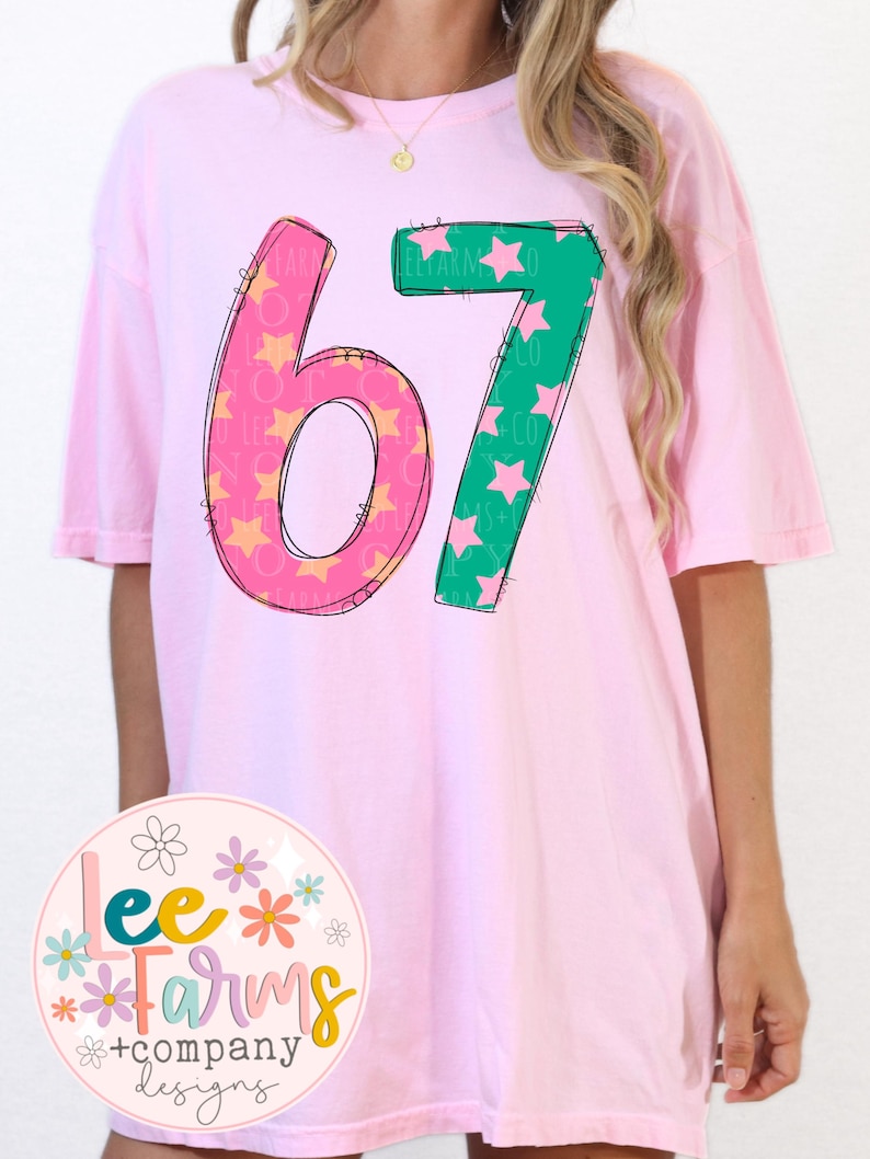 Pu&ograve; includere: T-shirt rosa chiaro oversize con il numero "67" in un design giocoso. Il "6" &egrave; rosa con stelle gialle e il "7" &egrave; verde con stelle rosa. La maglietta presenta anche un logo rotondo con testo ed elementi floreali.