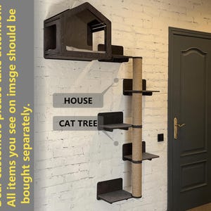 May include: A black cat tree with a house on top and multiple platforms. The cat tree is mounted on a white brick wall. The text "HOUSE" and "CAT TREE" are visible on the wall.
