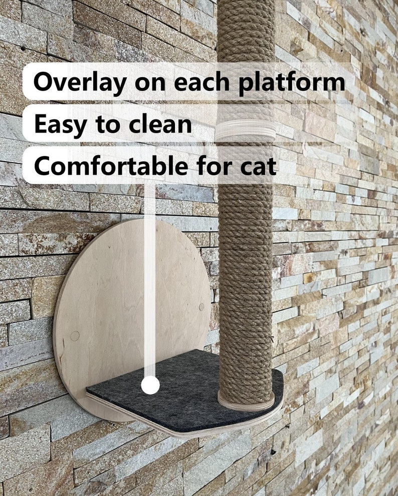 May include: A wall-mounted cat scratching post with a round platform and a sisal rope covered post. The platform is covered in a dark gray fabric. The text "Overlay on each platform", "Easy to clean", and "Comfortable for cat" is visible on the image.