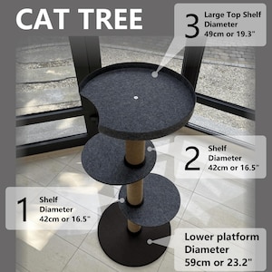 May include: Three-tier cat tree with dark gray shelves and a beige sisal-wrapped post.  The top shelf has a 49cm diameter, while the lower two shelves measure 42cm in diameter. The base platform is 59cm in diameter.  The cat tree is shown in a sunlit room.  Dimensions are labeled in both centimeters and inches.
