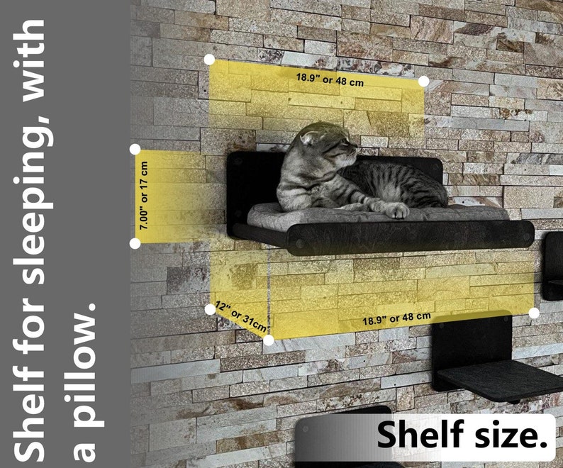 May include: A black cat bed shelf with a gray cushion. The shelf is 18.9 inches wide and 12 inches deep. The shelf is mounted on a brick wall.