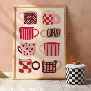 Op de afbeelding: Een printbare kunstprint met een verzameling van negen mokken met verschillende patronen, waaronder strepen, sterren en ruitjes. De mokken zijn allemaal roze en rood met bruine accenten. De tekst "COFFEE?" staat op een van de mokken.