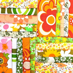 May include: A collection of fabric swatches featuring a variety of patterns including large orange and white flowers, small yellow floral prints, green and white stripes, and intricate botanical designs in shades of orange, yellow, green, and pink.