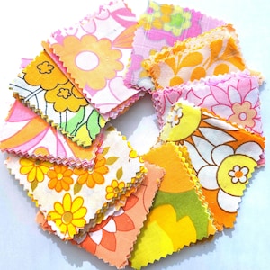 May include: A circular arrangement of square fabric swatches featuring various floral patterns in vibrant shades of orange, yellow, pink, and green. Each piece of fabric has pinked edges and displays distinct retro-inspired botanical prints.
