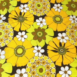 May include: A fabric with a repeating pattern of yellow, green, and white flowers on a brown background.