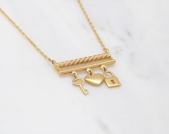 Collar con dije de candado y llave en forma de corazón en oro amarillo de 14 quilates