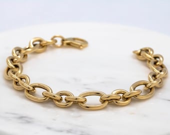 May include: A gold chain bracelet with large oval links.