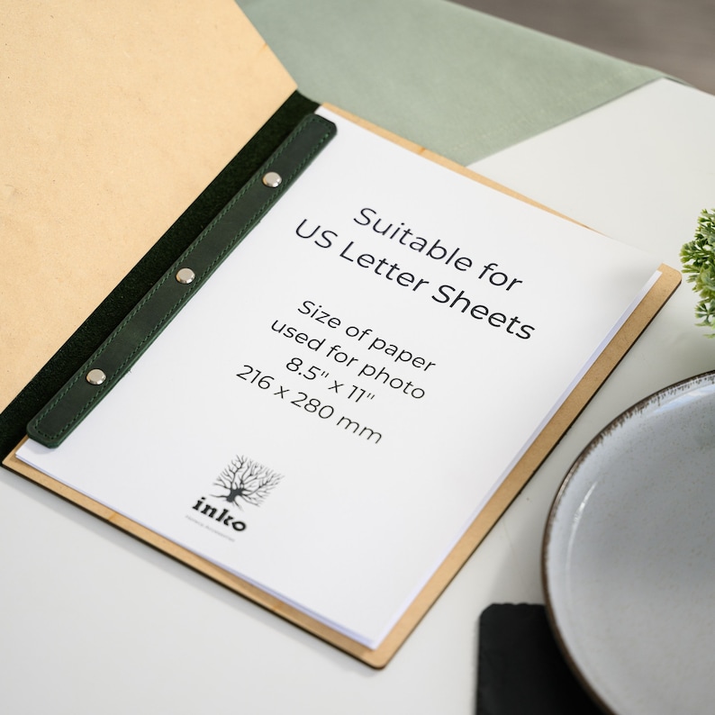 Size reference infographic for dark green Crazy Horse leather menu cover by Inko confirming compatibility with US Letter sheets sized 8.5 by 11 inches or 216 by 280 millimeters. Displays leather clamp bar binding system detail. Helps restaurants and cafes confirm paper size compatibility before ordering. Contact the Inko shop for custom size requirements or alternative paper format compatibility.