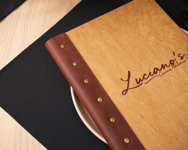 logo laser engraved on a plywood surface — close-up of the script version. The cursive font is clear and well-reproduced on the plywood. Script logos require good engraving resolution to render cleanly — thin strokes and curved lines can become indistinct if the laser settings aren't calibrated correctly for the specific plywood surface. This shot confirms the script engraving is clean and legible, which is important for buyers who want a typographic logo rather than an illustrated one.