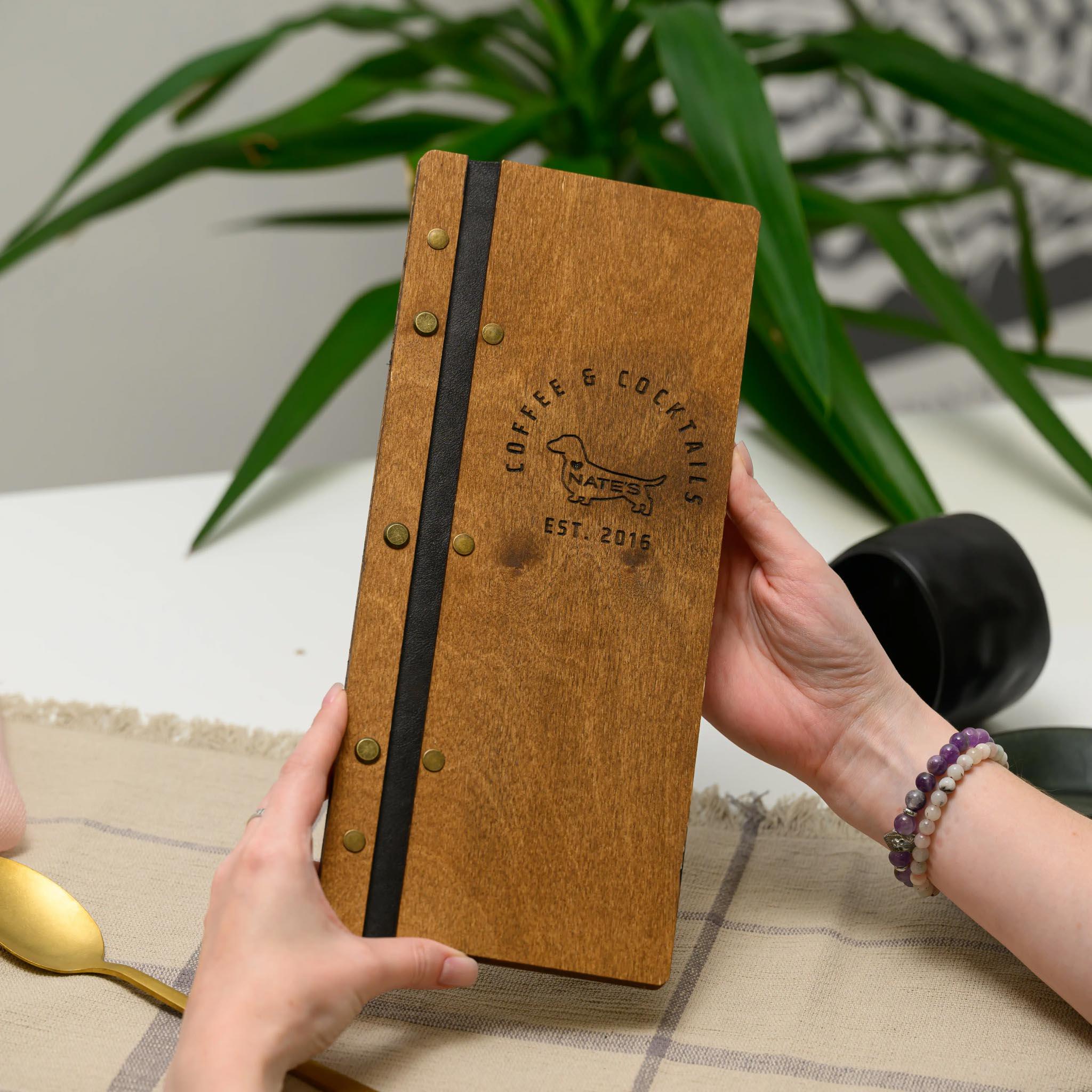 革ストラップに固定されたワインリスト用の木製メニューフォルダー