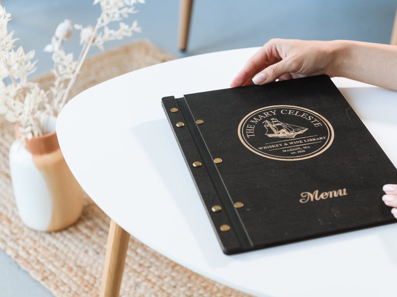 Elevate your brand with our Wooden Menu Holder featuring Logo Engraving. Personalize your presentation with ease using this handcrafted menu folder. Easily swap pages for a fresh, sophisticated look. Discover elegance with our Wooden Menu Cover.