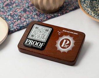 May include: A rectangular wooden QR code holder with the text "PROOF" and "ROOFTOP BAR - COCKTAIL LOUNGE". The holder also features the text "SCAN FOR OUR MENU" and a logo for "ROOF TOP BAR".
