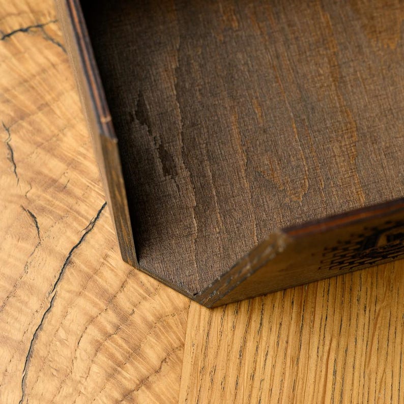 Extreme close-up of the corner joint and plywood layered edge of a dark walnut-stained napkin holder showing the precise box construction, plywood laminate stack, and smooth stained surface finish. Build quality detail of a handmade custom wooden restaurant napkin holder, demonstrating craftsmanship for buyers evaluating plywood construction quality of hospitality woodcraft accessories for pub and restaurant table service on Etsy.