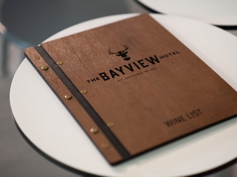 Elevate your brand with our Wooden Menu Holder featuring Logo Engraving. Personalize your presentation with ease using this handcrafted menu folder. Easily swap pages for a fresh, sophisticated look. Discover elegance with our Wooden Menu Cover.