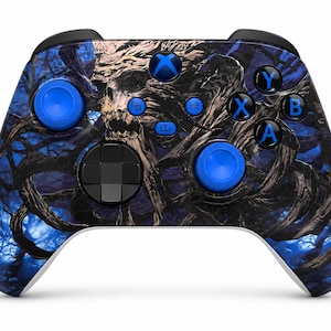 May include: A wireless video game controller featuring a dark blue and black graphic print of twisted tree branches and a skull. The device includes two bright blue thumbsticks, a black D-pad, and four action buttons labelled A, B, X, and Y.
