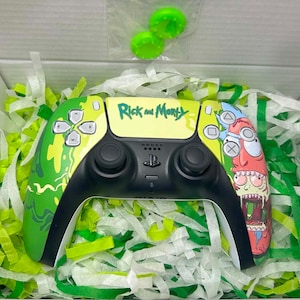 May include: A custom video game controller featuring a Rick and Morty theme with bright green and yellow accents, a black centre console, and a graphic of Rick Sanchez. Two lime green thumbstick covers are included in a small plastic bag.