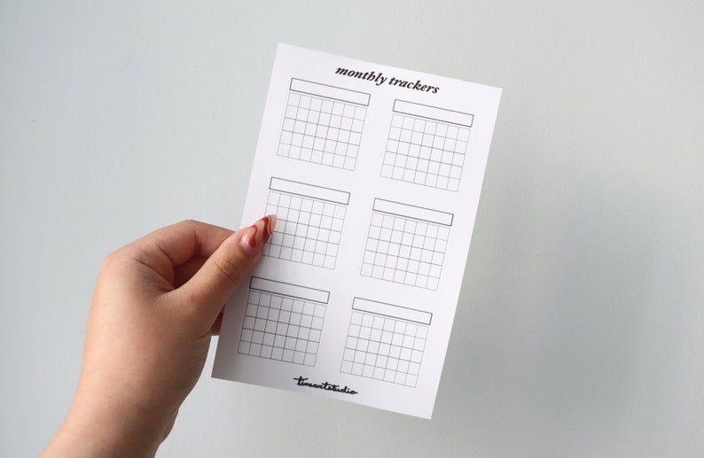 Op de afbeelding: Een printbaar vel met zes lege maandelijkse trackers. Elke tracker heeft ruimte voor een maandnaam en een raster met 30 vierkanten.