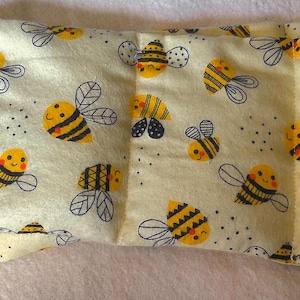 May include: A yellow fabric heating pad with a bee pattern. The pad is divided into sections and has a label that says "#320".