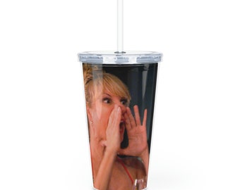 Puede incluir: Un vaso de plástico transparente con tapa negra y una pajita. El vaso tiene una foto de una mujer con cabello rubio, vistiendo una blusa roja, y haciendo una expresión de sorpresa con sus manos sobre su boca.