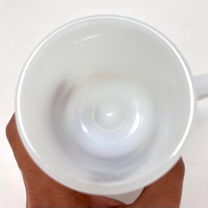 May include: A white ceramic mug with a smooth, glossy finish. The inside of the mug is clean and free of any stains.