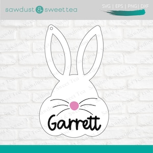Puede incluir: Corte de cabeza de conejo blanco con nariz rosa y bigotes. El nombre Garrett est&aacute; escrito en negro debajo de la nariz.