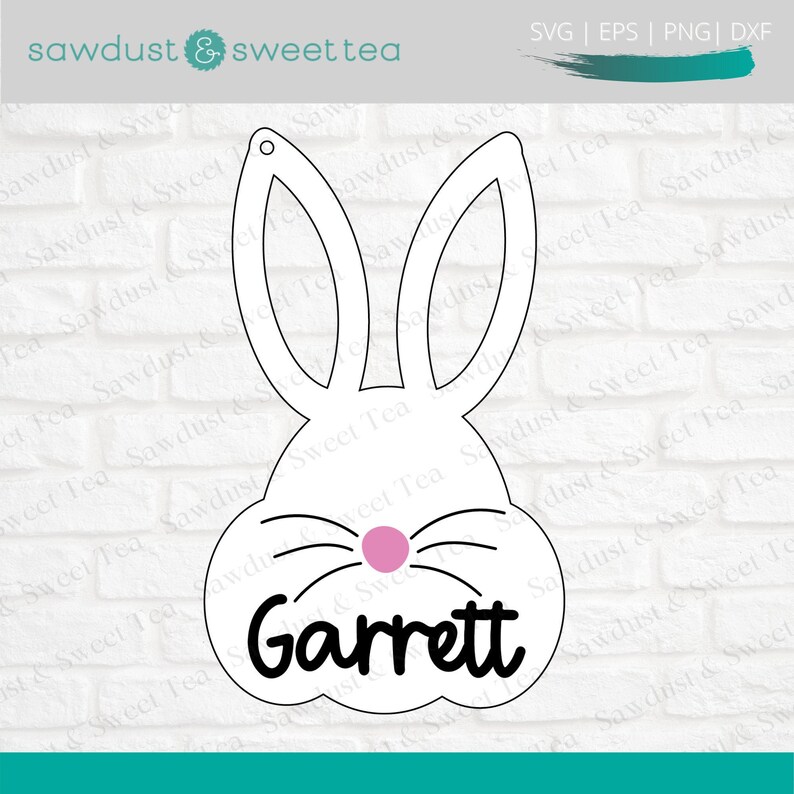 Puede incluir: Corte de cabeza de conejo blanco con nariz rosa y bigotes. El nombre Garrett est&aacute; escrito en negro debajo de la nariz.