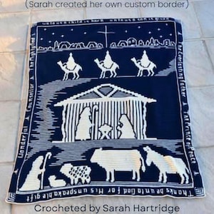 Könnte beinhalten: Eine marineblaue und weiße gehäkelte Decke mit einer Krippenszene. Das Design umfasst die heilige Familie, die Weisen, Tiere und Text. Die Decke hat einen Rand mit zusätzlichem Text. Der Text enthält "Wunderbarer Ratgeber" und "Dank sei Gott für sein unbeschreibliches Geschenk".