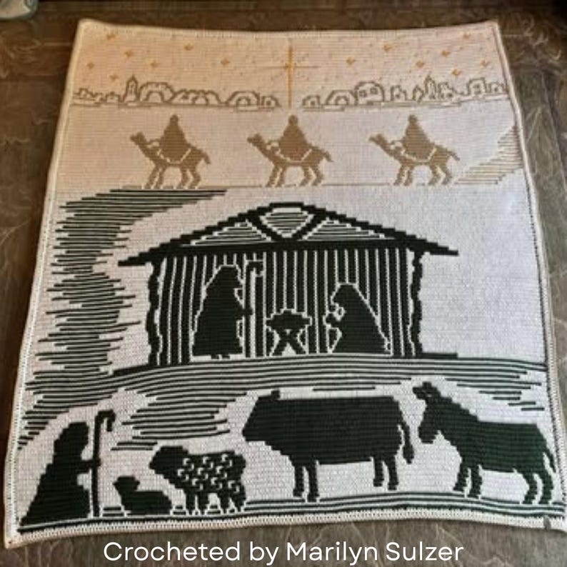 May include: A crocheted blanket featuring a nativity scene. The design includes silhouettes of the Holy Family, animals, and the Three Wise Men on camels. The text "Crocheted by Marilyn Sulzer" is at the bottom.