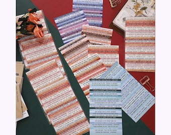 Peut inclure: Une collection de bandes de papier décoratives avec du texte imprimé en différentes couleurs, notamment des nuances de bleu, de marron et d'orange. Les bandes sont disposées en piles, certaines dans un emballage plastique transparent.