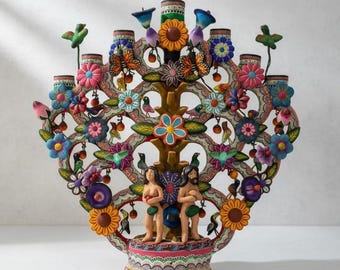 Puede incluir: Una colorida escultura artesanal del Árbol de la Vida. El árbol presenta detalles intrincados, incluyendo flores, pájaros, mariposas y figuras. La base y las ramas están adornadas con pintura vibrante, creando una pieza decorativa y simbólica.