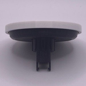 May include: A white and black plastic circular base with a black plastic stem and a black plastic clip.