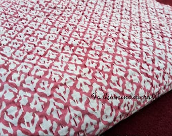 May include: Pink and white kantha quilt with a floral pattern. The quilt is hand-stitched and has a traditional Indian design.